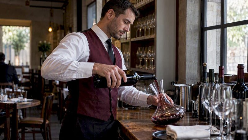 Sommelier carefully pouring wine into a decanter